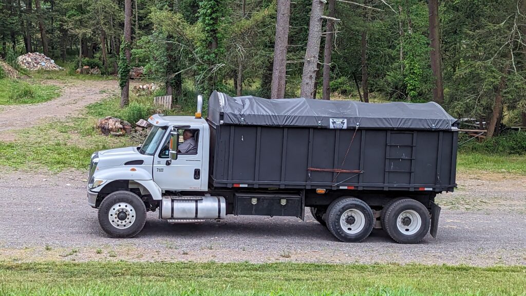 Black and white dump truck with a Keystone Tarps roll tarp system